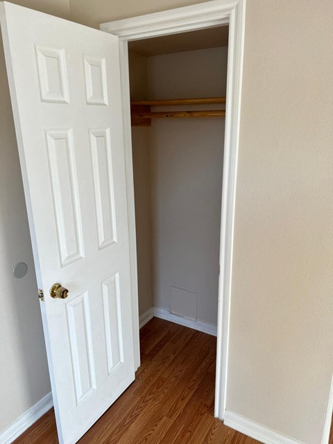 an empty room with a closet and a door open