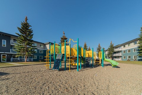 a playground at an apartment complex with a large playset