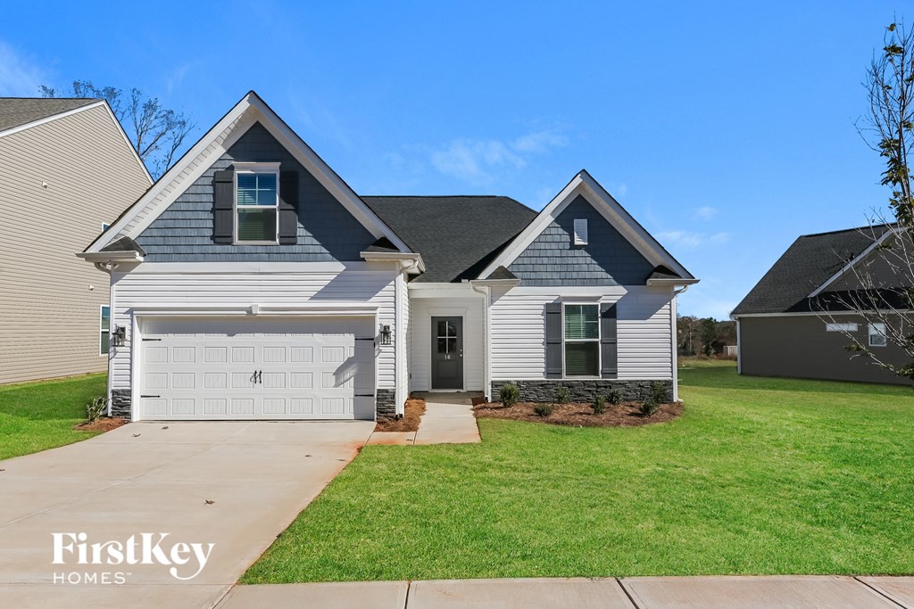 A house with a garage and a driveway in front of it.