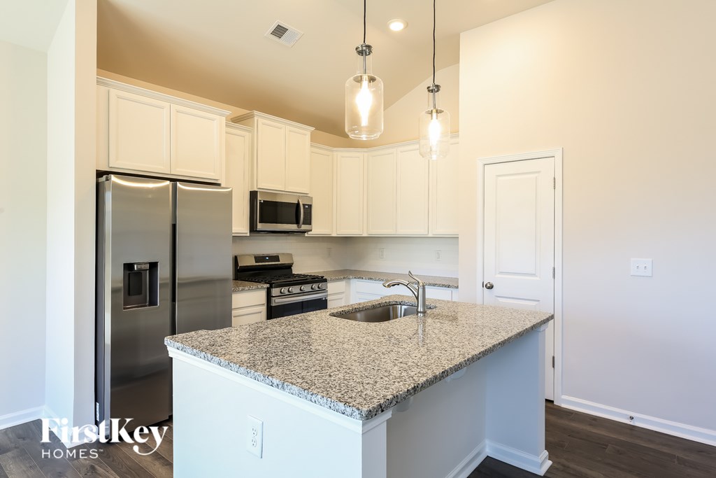 A kitchen with granite countertops and stainless steel appliances.