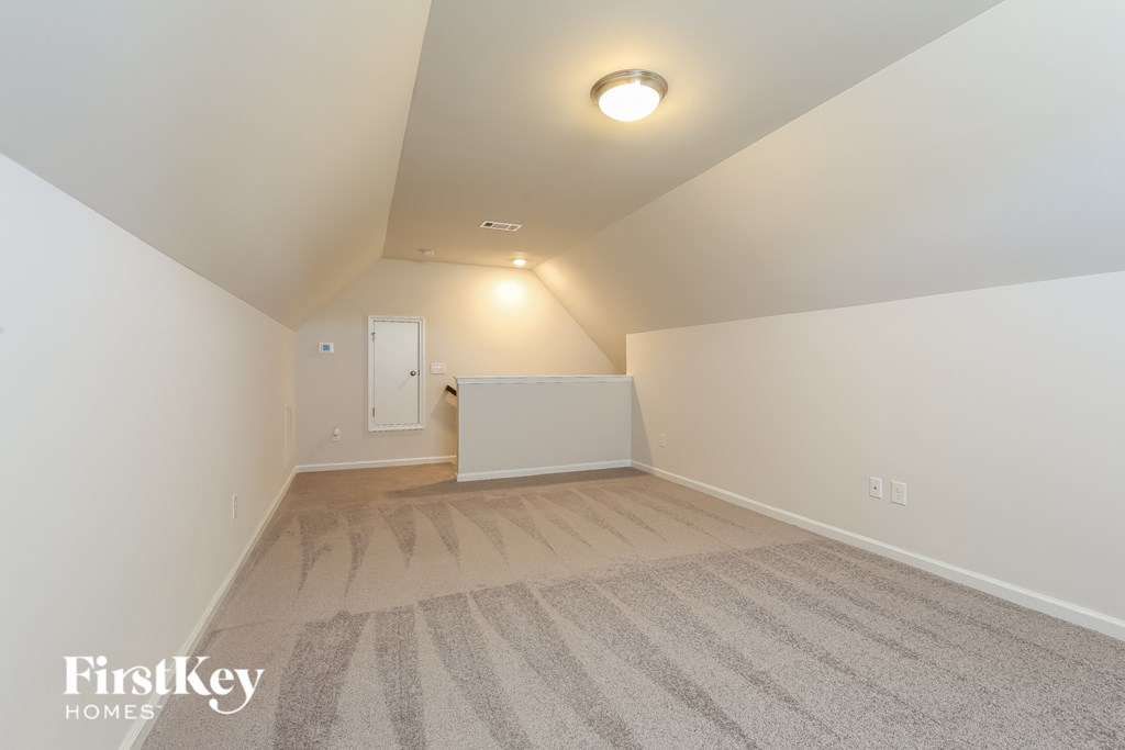 A room with a carpet and a light on the ceiling.