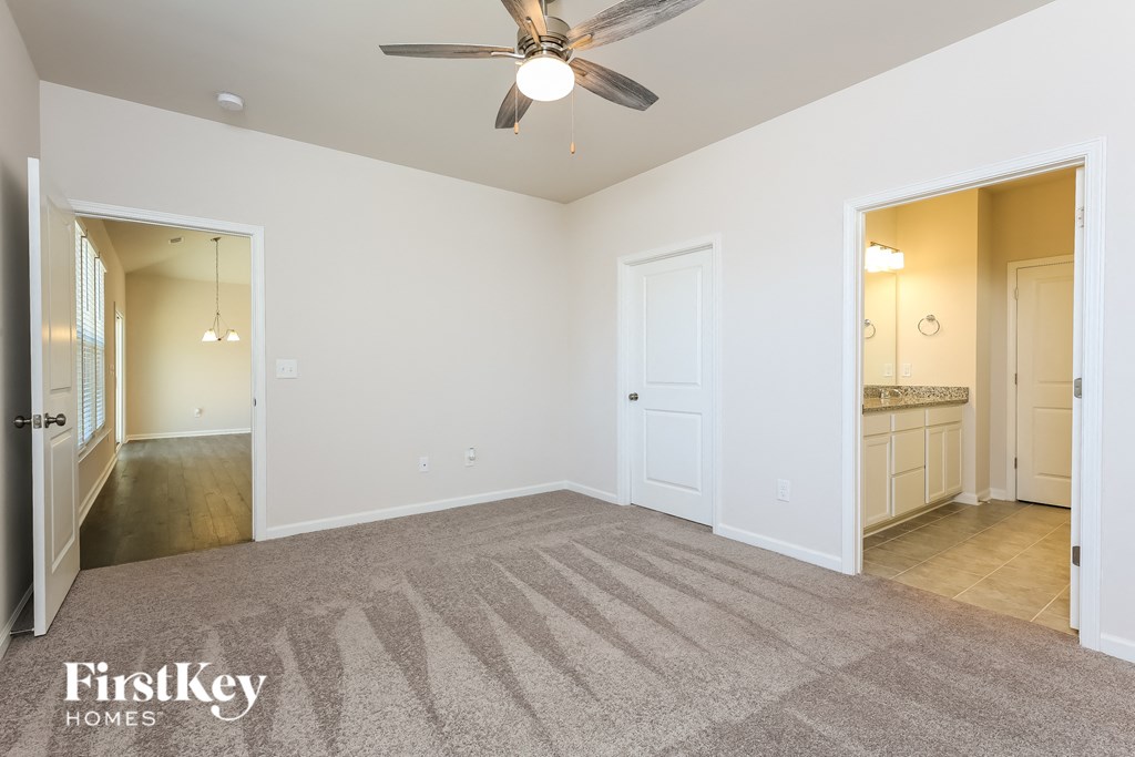A spacious room with a fan and carpeted floor.