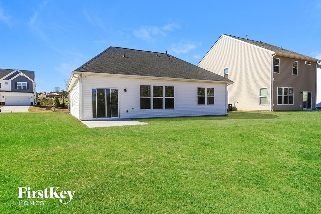 A white house with a black roof is in the foreground with a blue sky in the background.
