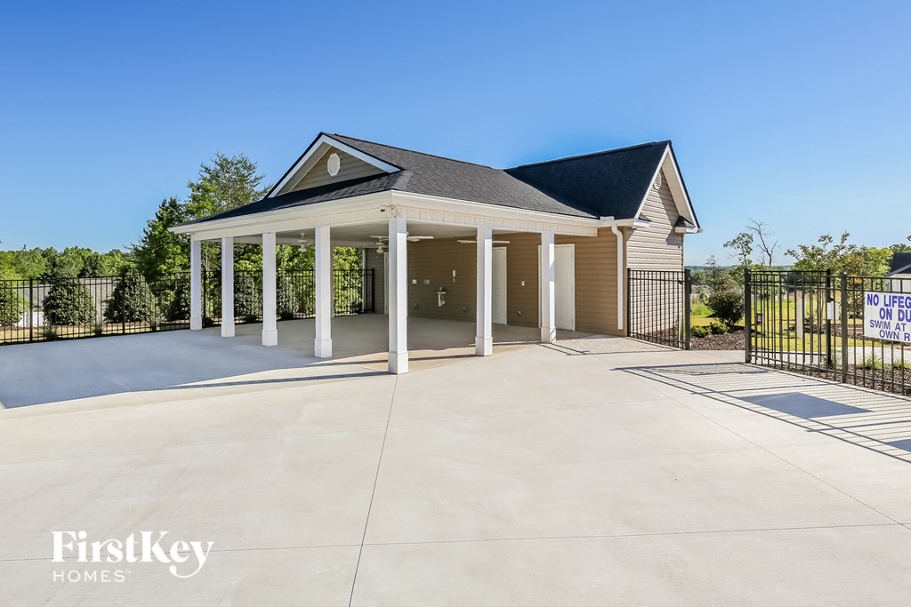 A house with a large front porch and a sign that says "For Sale".