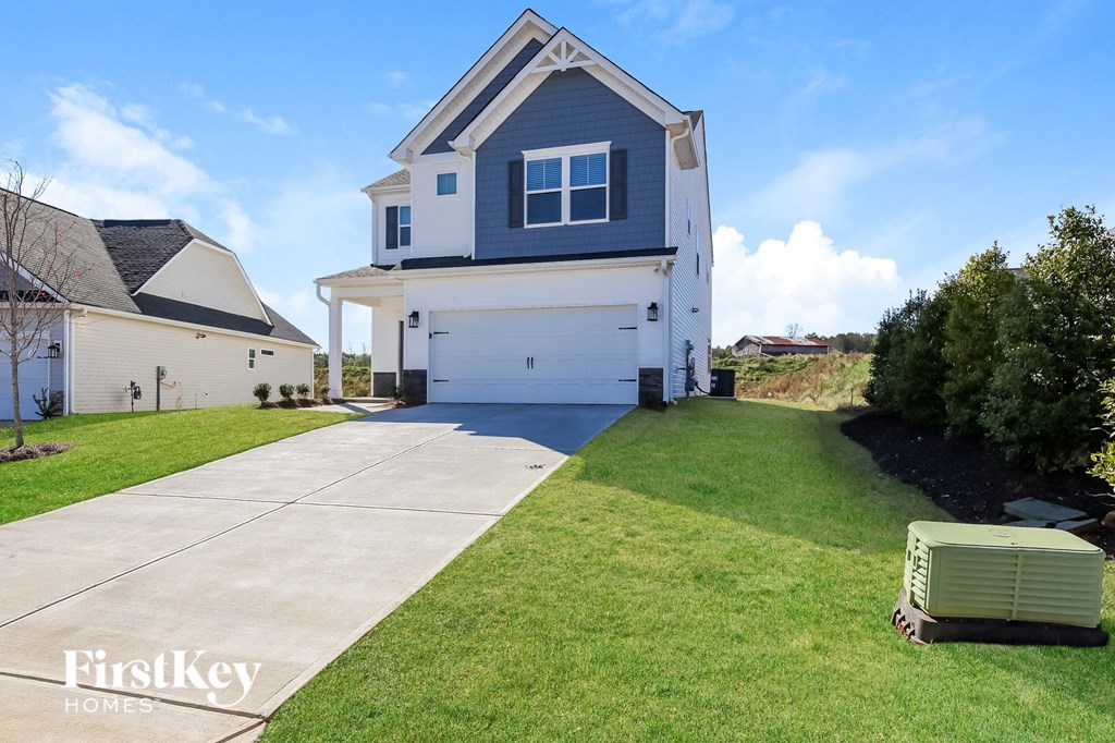 A house with a garage and a driveway in front of it.