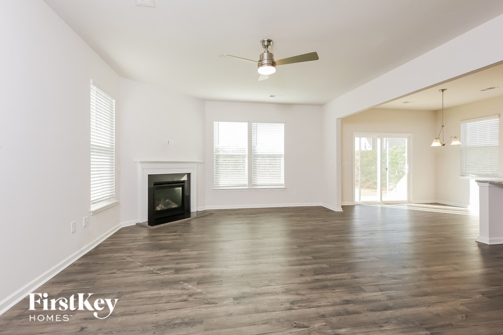 A spacious living room with a fireplace and wood flooring.