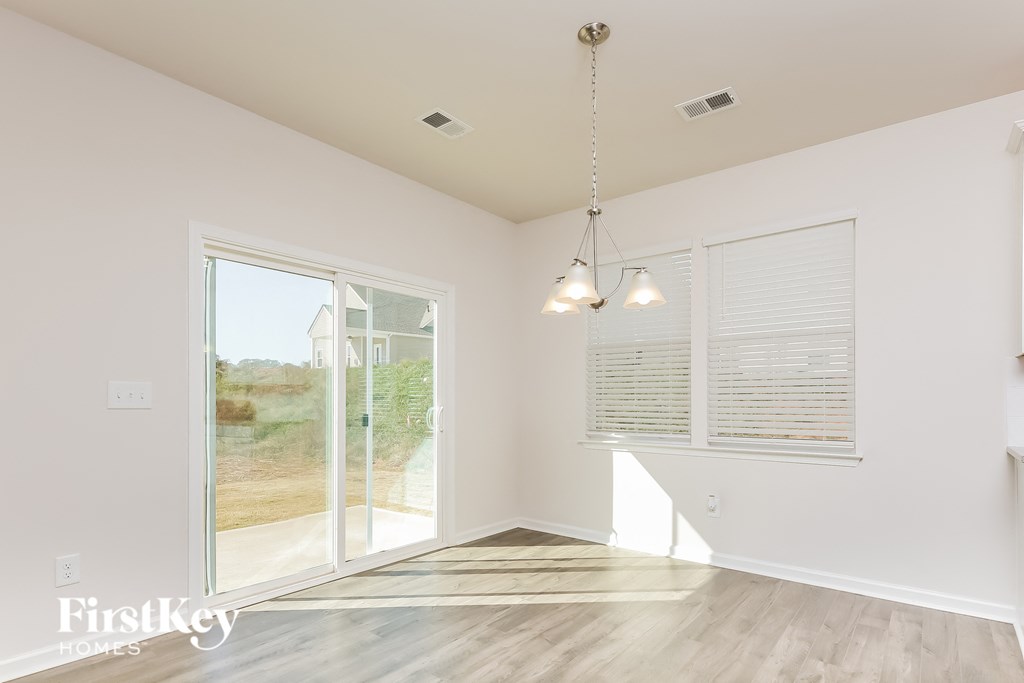 A room with a sliding glass door and a wooden floor.