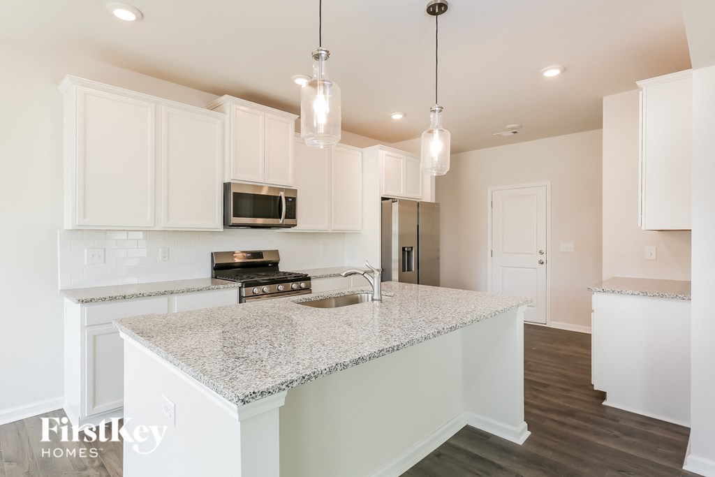 A kitchen with a granite countertop and white cabinets.