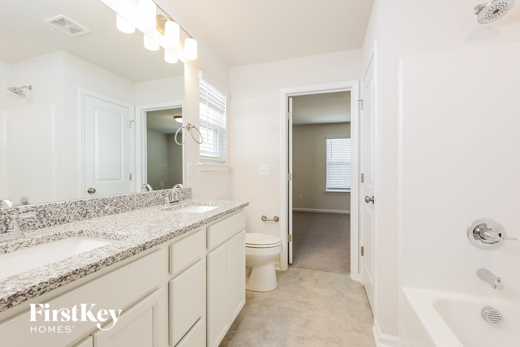A bathroom with a white tub, sink, and toilet.