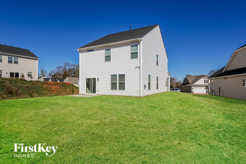 A white house with a green lawn in front of it.