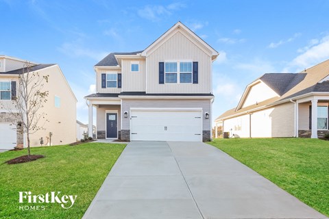 a white house with a white garage door and a driveway