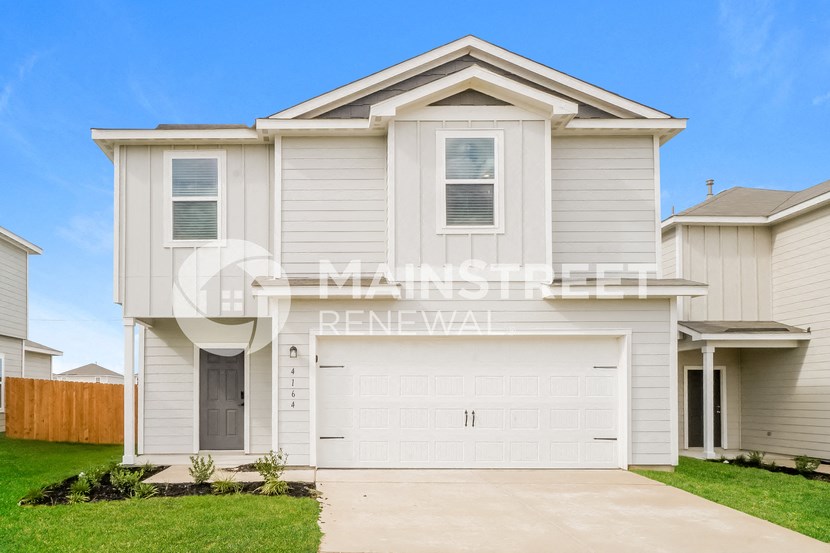 two story house with a garage and a lawn