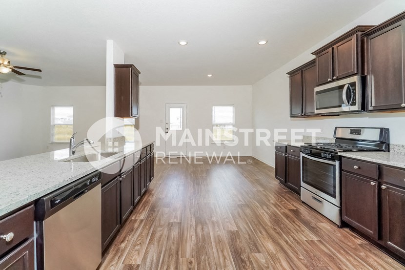 a large kitchen with wood flooring and a large counter top