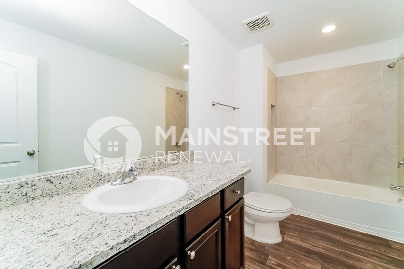 a bathroom with a sink and a toilet and a bath tub