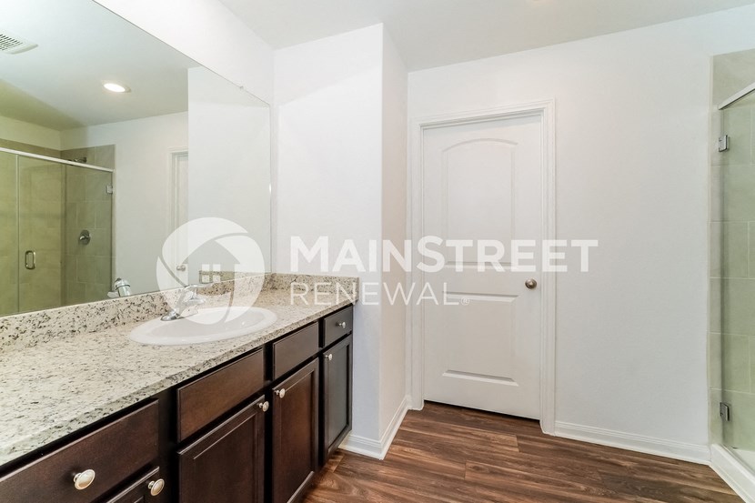 a bathroom with a sink and a mirror and a shower