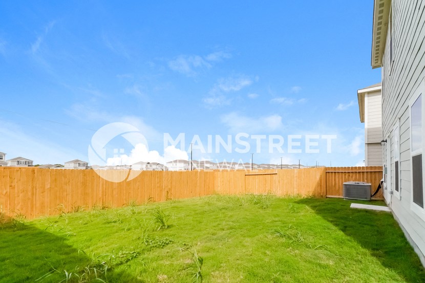 a backyard with a wooden fence and grass