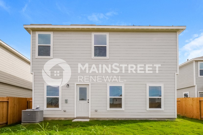 a small white house with a yard in front of it