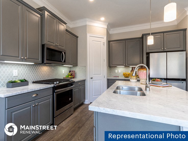 a kitchen with gray cabinets and a white counter top