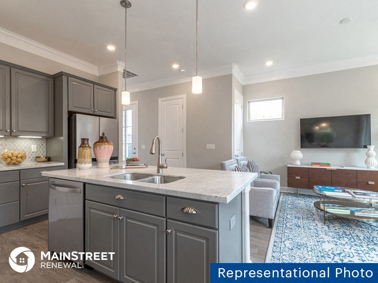 a kitchen with gray cabinets and a sink and a counter top