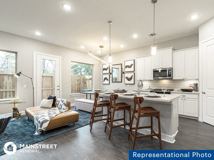 a kitchen and living room with a table and chairs