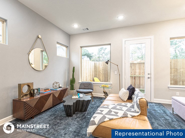 a living room with a couch and a chair and a window