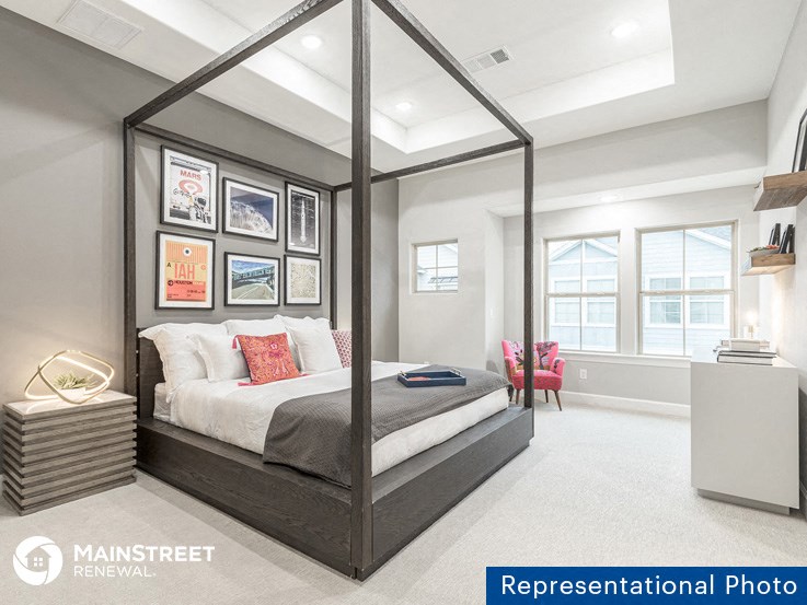 a bedroom with a bed and a dresser and a window