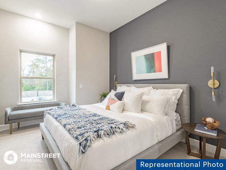 a bedroom with a large bed and a window