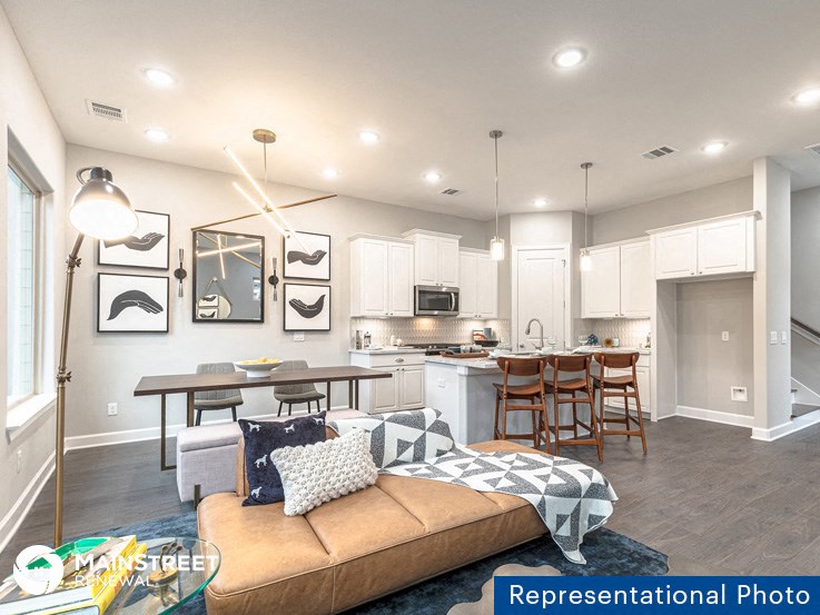 a living room and kitchen with a couch and a table