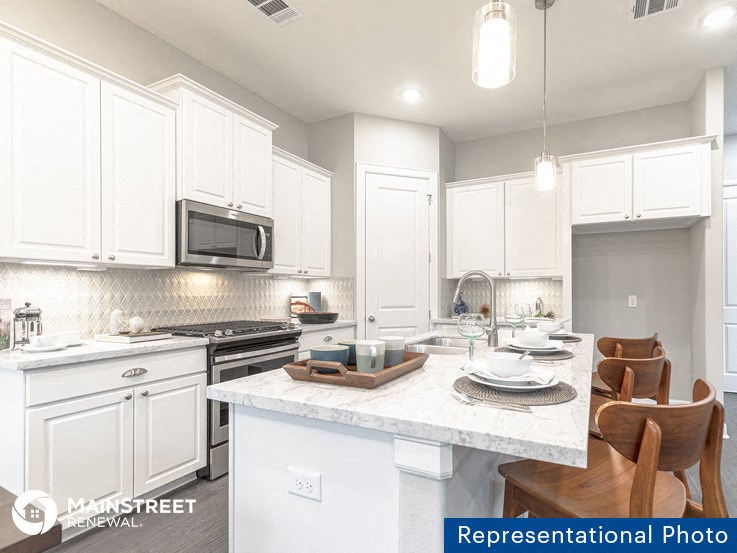 an image of a kitchen with white cabinets and a marble counter top