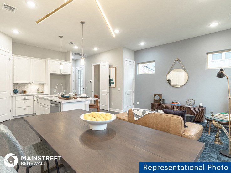 a kitchen and dining room with a table and a bowl of fruit
