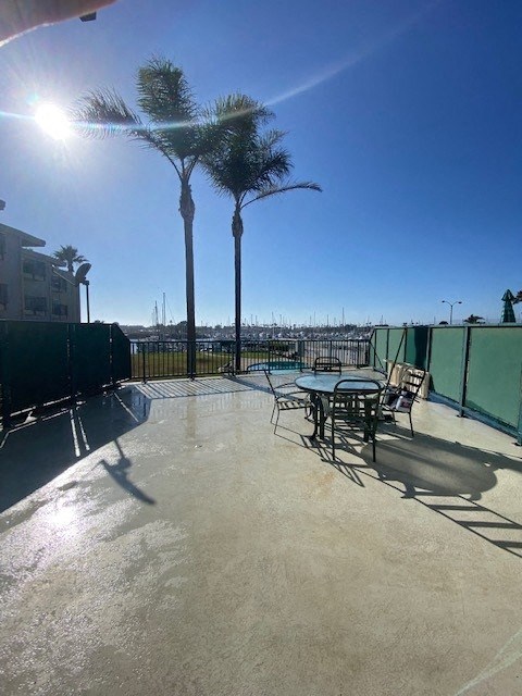 a patio with a table and chairs and palm trees