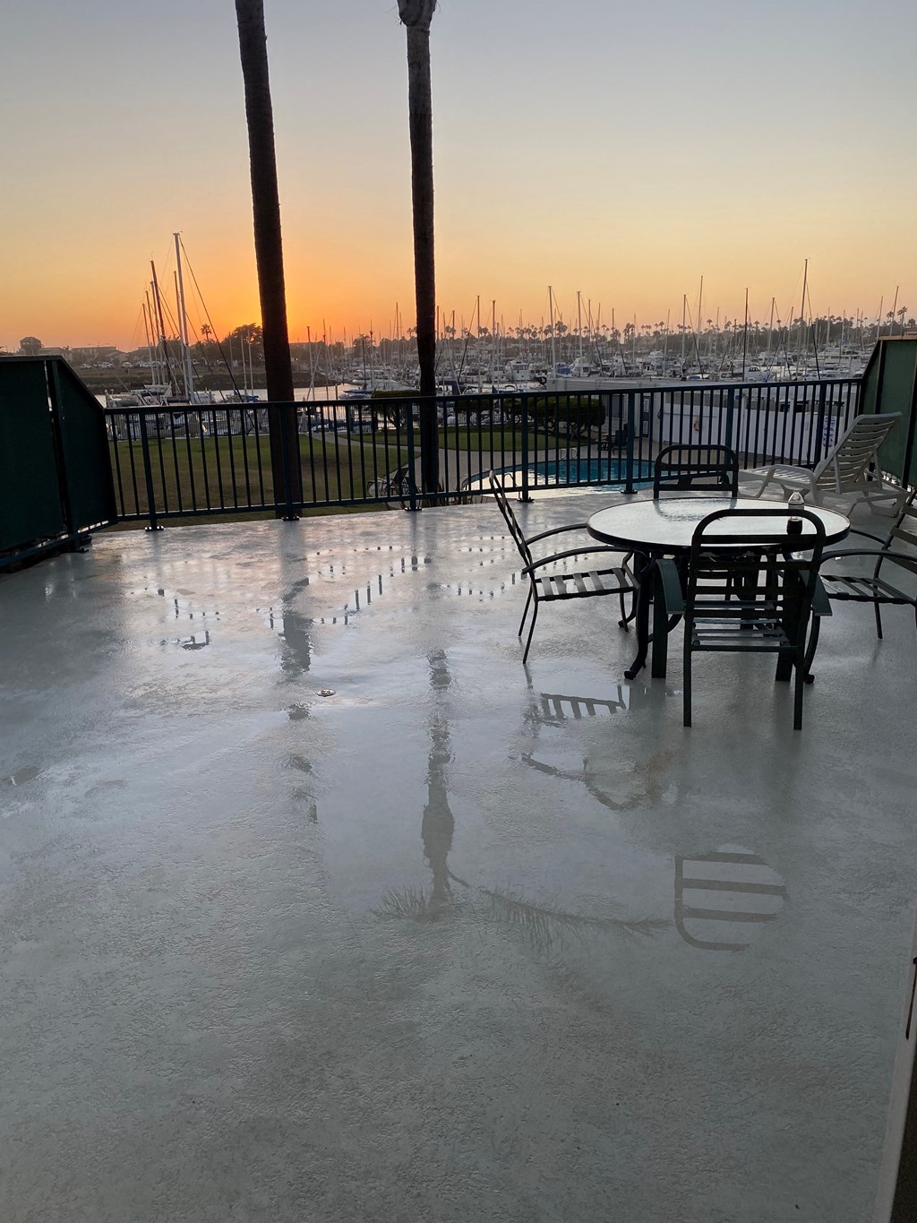 a patio with tables and chairs and water on the floor