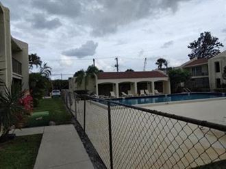a house with a swimming pool and a chain link fence