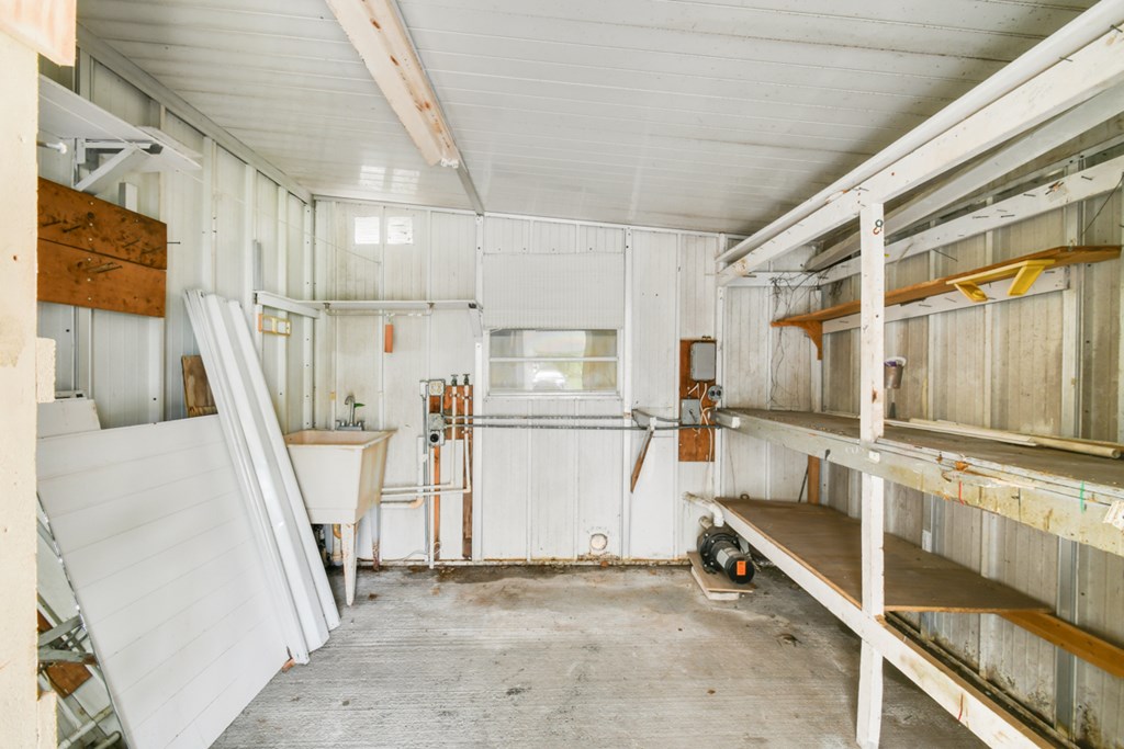 A room with a white ceiling and walls, and a concrete floor.