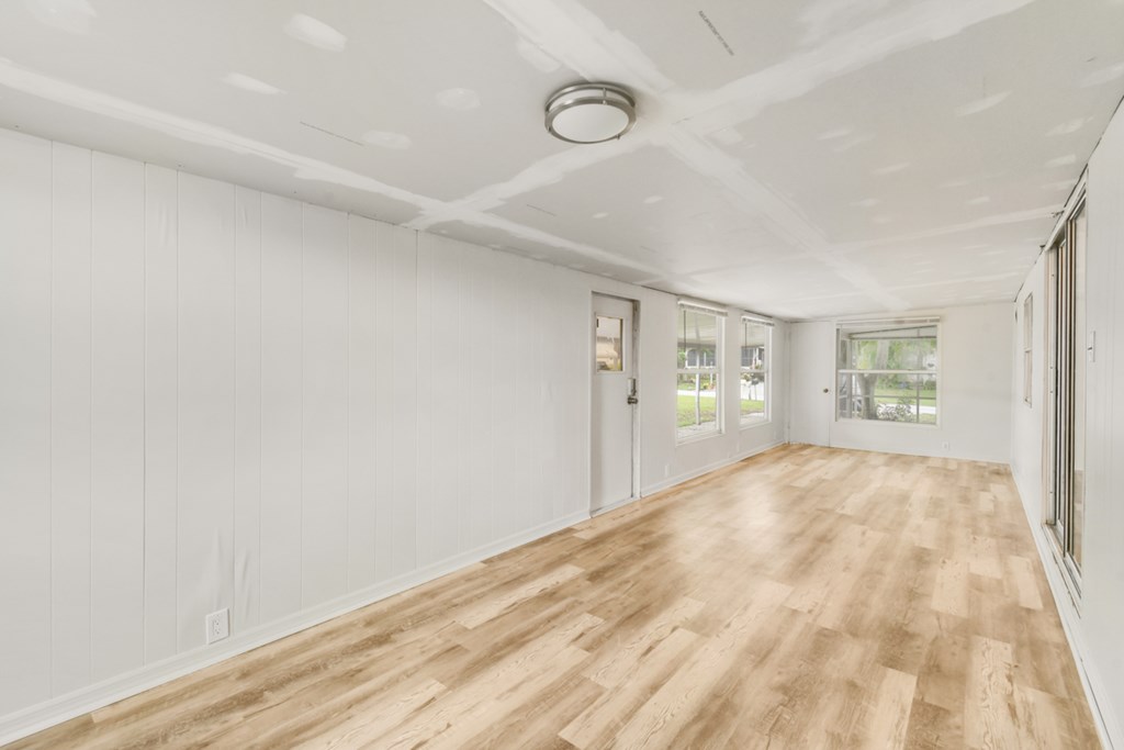 A room with wooden flooring and white walls.