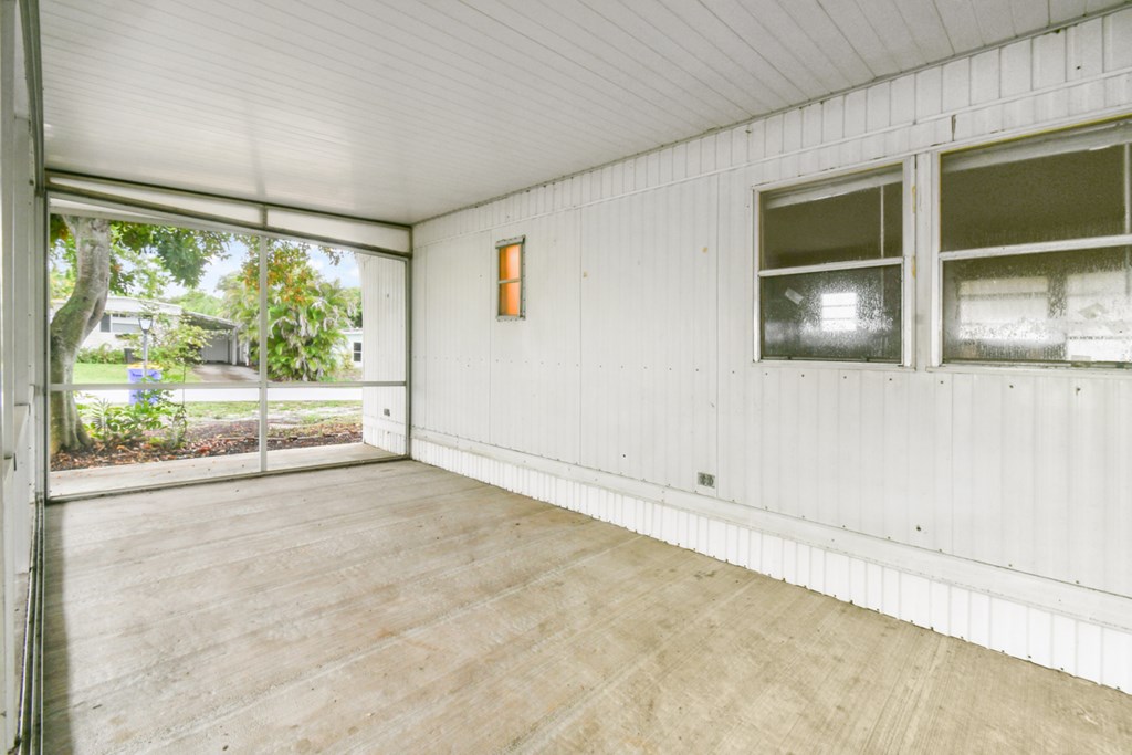 A room with a white wall and a window.