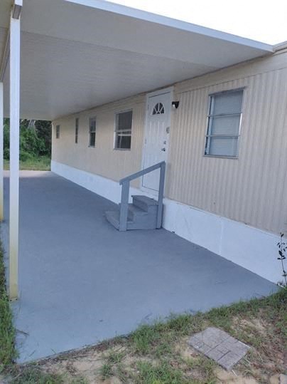 A white building with a grey door and windows.