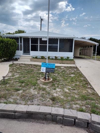 a small house with a sign in front of it