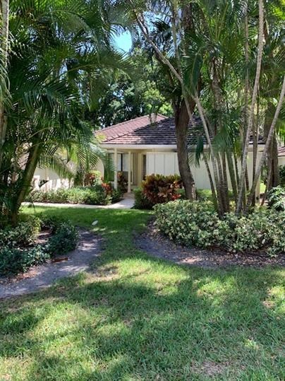 a house with palm trees and grass in front of it