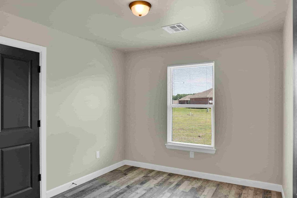 an empty room with a window and a black door