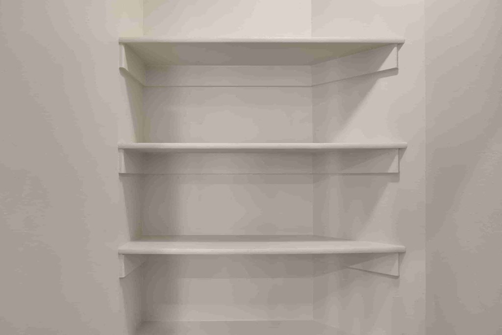 a white shelving unit in a white closet