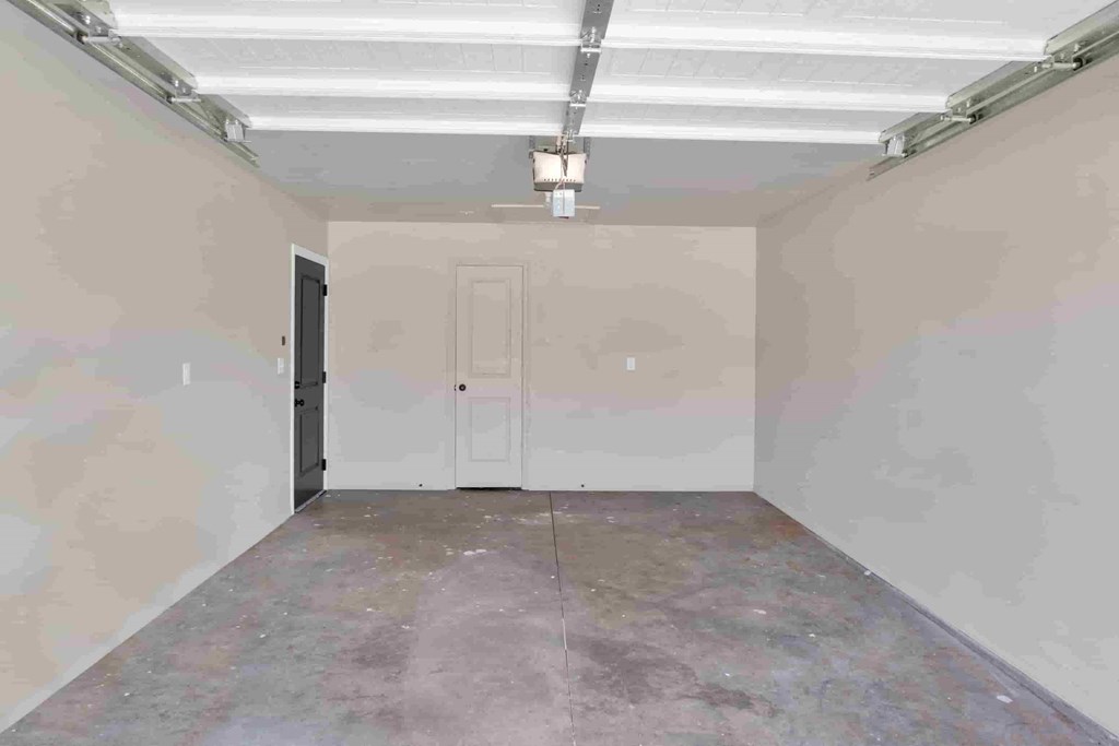 an empty room with a white door and a ceiling light