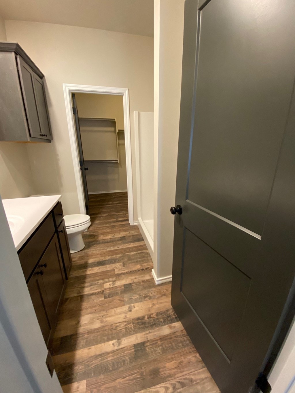 a bathroom with a toilet and a sink and a hallway with a door
