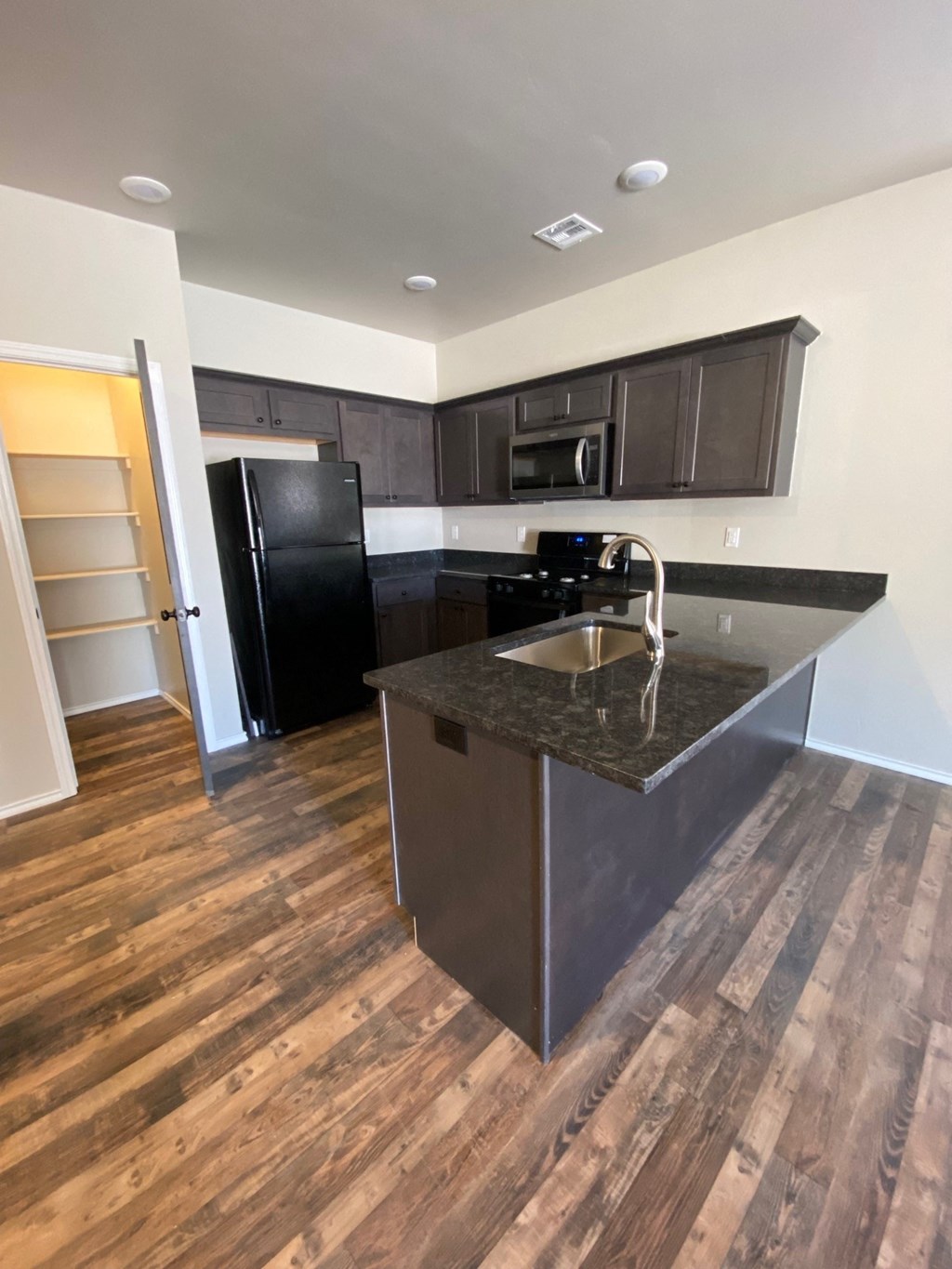 a view of a kitchen with black appliances and a counter top