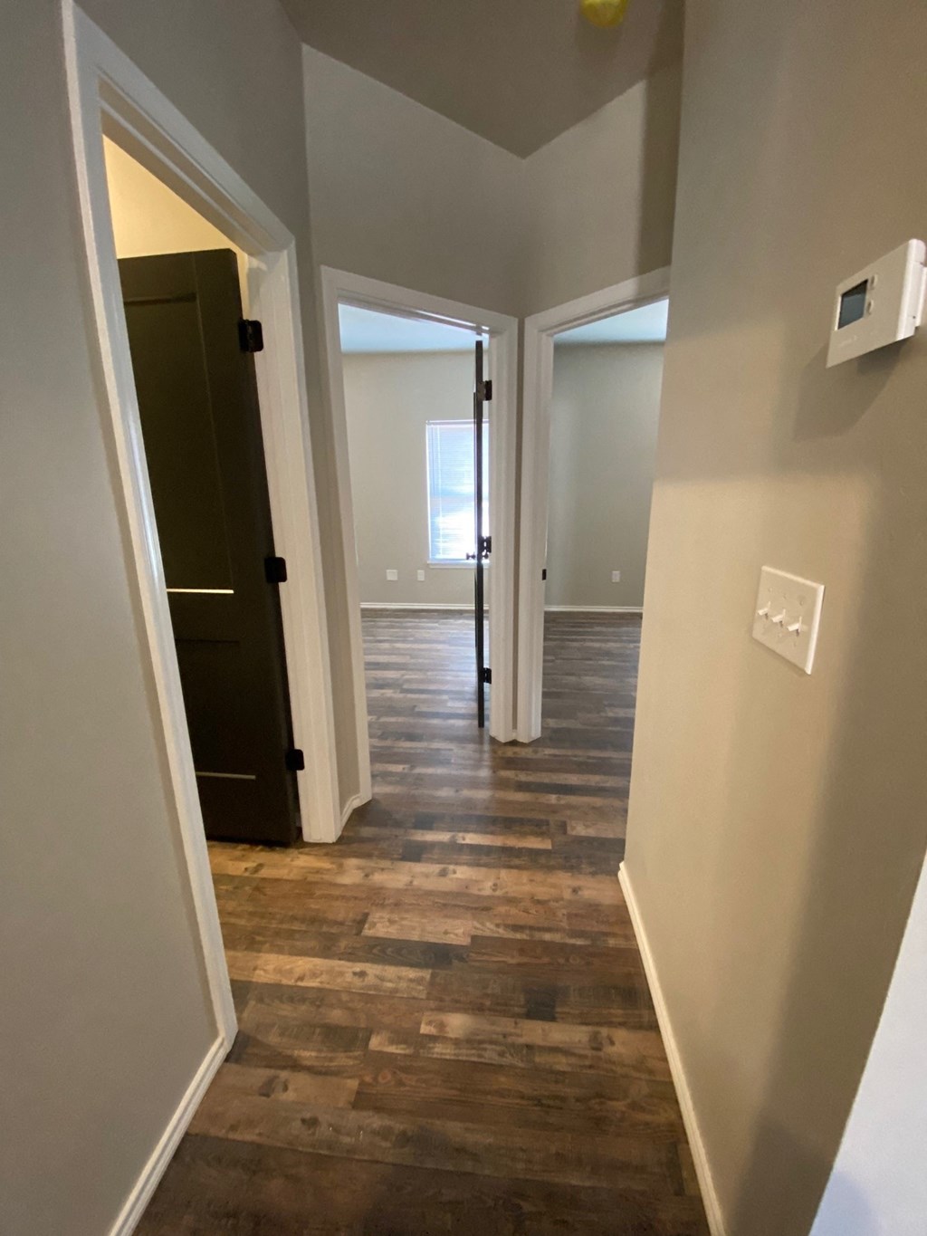 a look down the hallway of a new home with a hard wood floor