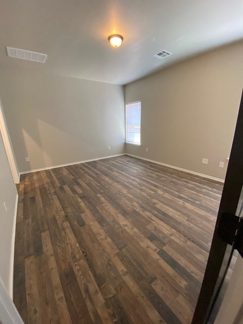 a living room with wood floors and a window