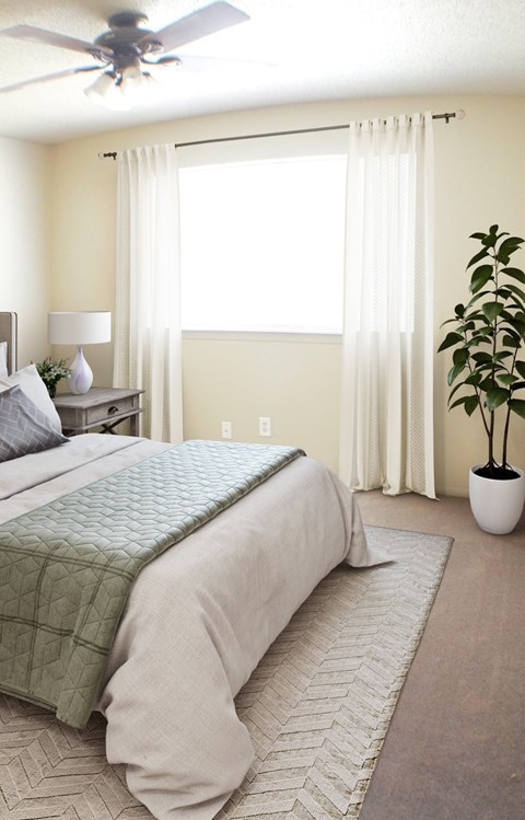 A bedroom with a large bed and a ceiling fan.