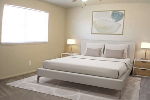 A white bed with a white headboard and two white pillows sits in a room with a white ceiling and a white wall.