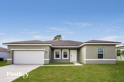 a beige house with a lawn and a garage door