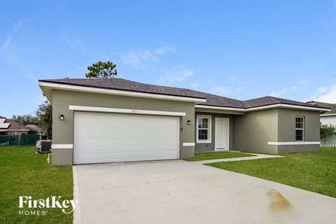 a beige house with a driveway and a garage door